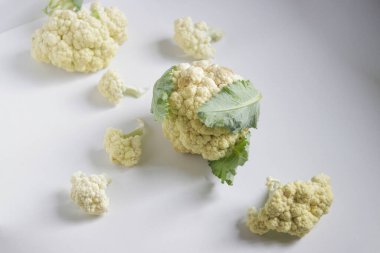 Beyaz arka planda yeşil yapraklı lahana çiçeği olarak da bilinen taze organik karnabahar.