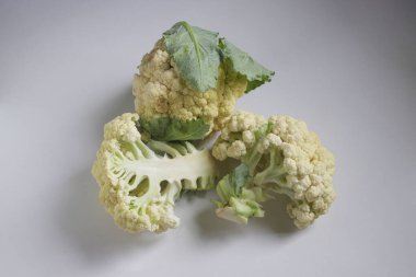 Beyaz arka planda yeşil yapraklı lahana çiçeği olarak da bilinen taze organik karnabahar.