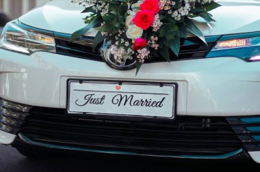 Plakası olan güzel, beyaz bir düğün arabası.