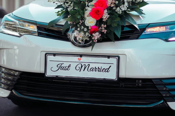 Plakası olan güzel, beyaz bir düğün arabası.