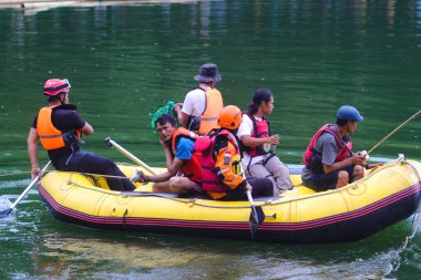 Sukabumi, Batı Java, Endonezya - 3 Ekim 2021: şişme bir teknede can yelekleri bulunan bir grup Endonezya arama kurtarma ordusu (Tim SAR) Batukarut Gölü 'nde boğulan bir cesedi arıyor.