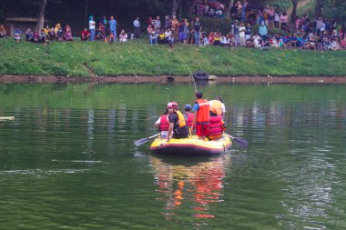 Sukabumi, Batı Java, Endonezya - 3 Ekim 2021: şişme bir teknede can yelekleri bulunan bir grup Endonezya arama kurtarma ordusu (Tim SAR) Batukarut Gölü 'nde boğulan bir cesedi arıyor.