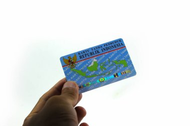 Sukabumi, Batı Java, Endonezya - 14 Ekim 2021: Asyalı bir adamın sol eli, E-KTP adında bir Endonezya Elektronik Kimlik Kartı tutuyor..