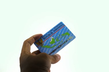 Sukabumi, Batı Java, Endonezya - 14 Ekim 2021: Asyalı bir adamın sol eli, E-KTP adında bir Endonezya Elektronik Kimlik Kartı tutuyor..