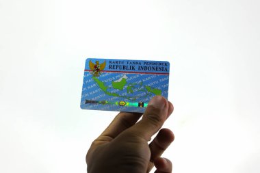 Sukabumi, Batı Java, Endonezya - 14 Ekim 2021: Asyalı bir adamın sol eli, E-KTP adında bir Endonezya Elektronik Kimlik Kartı tutuyor..