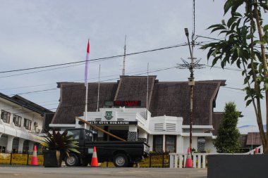 Sukabumi, Batı Java, Endonezya - 18 Aralık 2021: Önünde trafik konileri, elektrik direği ve Endonezya bayrağı bulunan Sukabumi Belediye Binası (Balai Kota Sukabumi) geniş görünümü