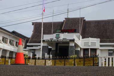 Sukabumi, Batı Java, Endonezya - 18 Aralık 2021: Önünde trafik konileri, elektrik direği ve Endonezya bayrağı bulunan Sukabumi Belediye Binası (Balai Kota Sukabumi) geniş görünümü