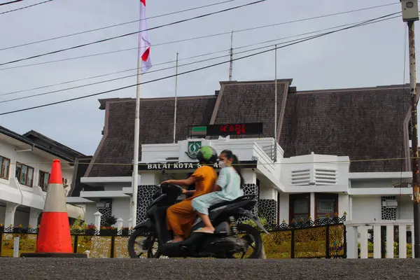 2021年12月18日 印度尼西亚西爪哇 苏加布米 一名骑摩托车的骑手戴着面具骑自行车 但不戴头盔经过苏加布米市政厅前 — 图库照片