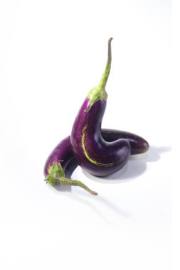 Beyaz arkaplanda izole edilmiş uzun mor patlıcanın yakın görüntüsü.