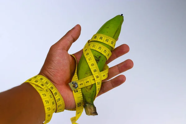 Hand Holding Green Banana Wrapped Measuring Tape Isolated White Background — Fotografia de Stock