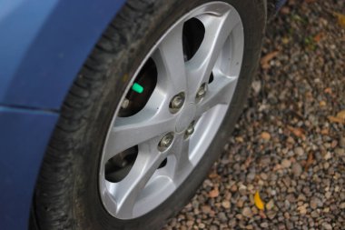 Araba sürmeden önce güvenlik kontrolü ve araba bakımı konseptini göstermek için yerdeki araba tekerleğinin yakın görüntüsü