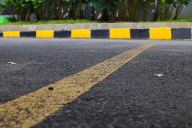 Otoparktaki çatlak asfalt yolda sarı çizgilerle soyut arka plan defocus. Sarı çizgili çatlak asfalt arkaplan