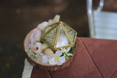 Kırsal alyans kutusunun, ahşap bir yerde çiçeklerle süslenmiş görüntüsünü kapat.