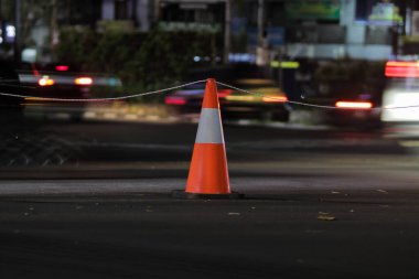 Sukabumi, Batı Java, Endonezya 'daki Covid-19 Salgını' nın önlenmesini gösteren trafik konisi ve bulanık arka plan.
