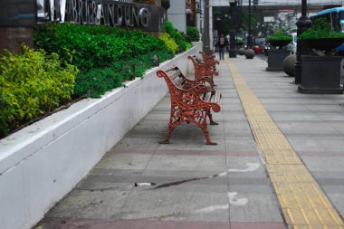 Bandung, Batı Java, Endonezya - 10 Ocak 2022: Turistler için Asya Afrika Caddesi kaldırımında sıralanmış çok sayıda antika park bankları.