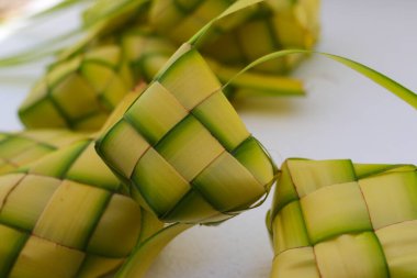 Kupat 'ın seçmeli odak noktası, ketupat, ya da beyaz arkaplanda ucu. Ketupat, genellikle Hari Raya ya da Kurban Bayramı 'nda servis edilen ikonik pirinç keki. Ketupat kesesi örülmüş genç hindistan cevizi yapraklarından yapılır.