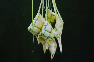 Boş ketupat derisi ya da yeşil arka planlı ketupat kesesi grubunun yakın görüntüsü. Ketupat genellikle Hari Raya ya da bayram zamanında servis edilir. Ketupat kesesi örülmüş genç hindistan cevizi yapraklarından yapılır.