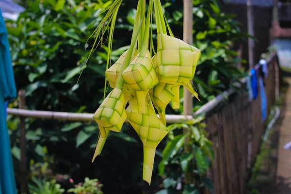 Close-up view of Ketupat or Kupat with blurred background. Ketupat is an iconic rice cake that usually served during Hari Raya or eid mubarak. Ketupat pouch is made of woven young coconut leaves