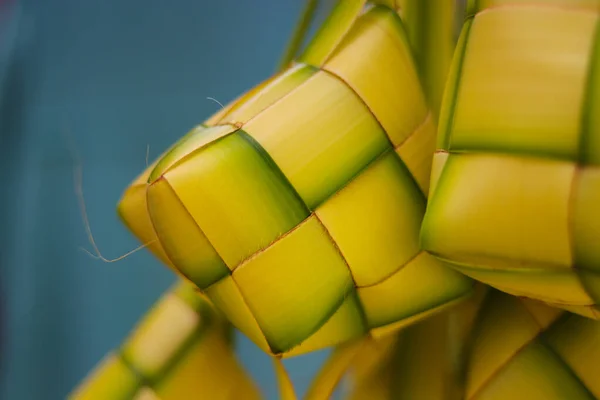 Close-up view of Ketupat or Kupat with blurred background. Ketupat is an iconic rice cake that usually served during Hari Raya or eid mubarak. Ketupat pouch is made of woven young coconut leaves