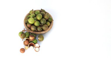 Beyaz arka planda izole edilmiş ahşap bir kasede fotokopi alanı olan Macadamia fıstıklarının üst görüntüsü