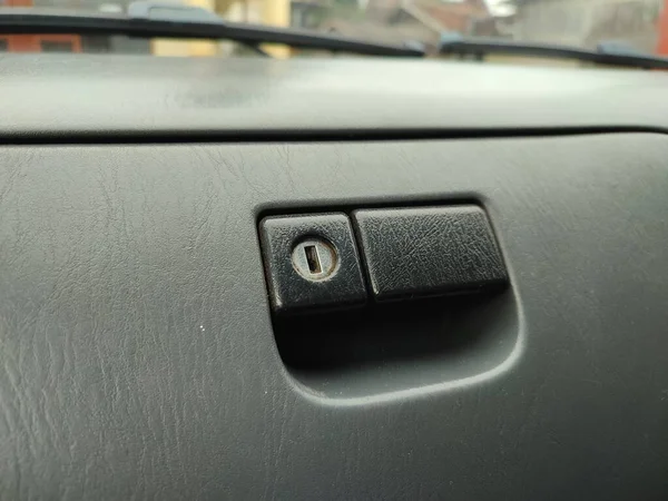 car storage compartment key hole on an old car interior