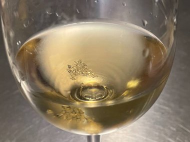 wine tartrate crystals on the bottom of a glass of white wine clipart