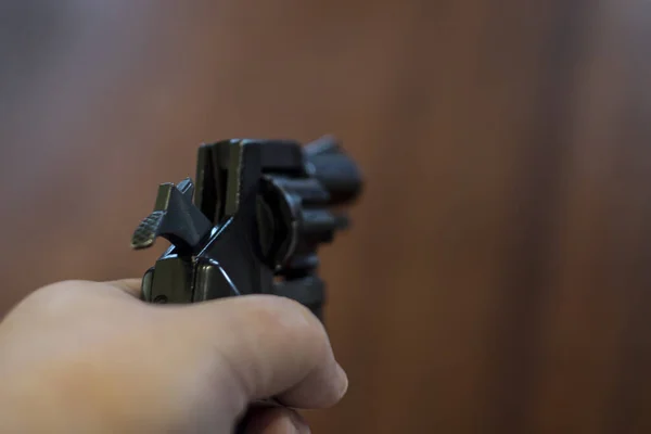 Handen håller en pistol och siktar i fjärran — Stockfoto