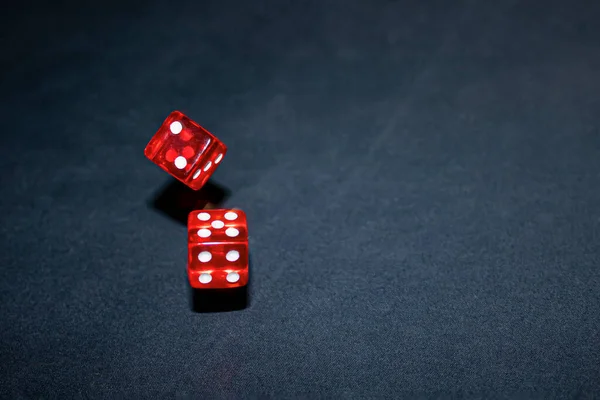 Freeze red dice in motion on a dark background with copy space Лицензионные Стоковые Изображения