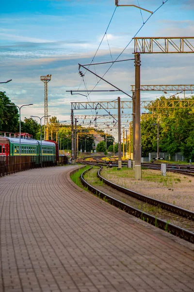 Vasútállomás vonatok naplementekor kék ég, hosszú út — Stock Fotó