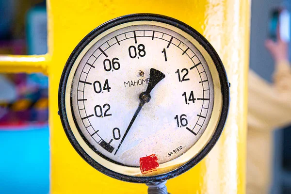 Sarı renkli bir borunun arka planında gaz manometresi.