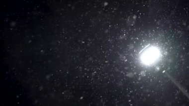 Bir elektrik direğine karşı siyah arkaplan üzerinde parçacıklar