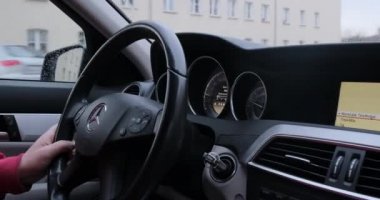 Adam güpegündüz şehirde araba kullanıyor.