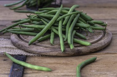 Green beans on wooden cutting board. Go green concept. High quality photo