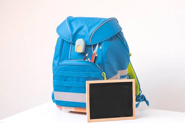 Soon to school. School backpack with writing supplies on the table