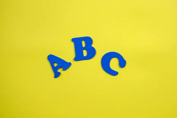 Back to school supplies and letters on yellow background. Beginning of the school year. ABC