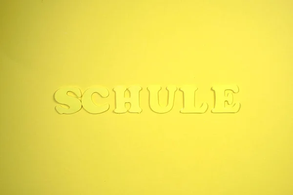 Word Schule Means School. Yellow background, yellow letters. School education