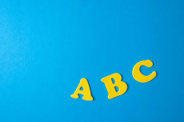 Back to school supplies and letters on a blue background. Beginning of the school year. Blue yellow colors.