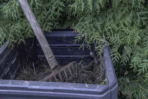 Garden shovel on compost. Compost preparation. Compost box in autumn.