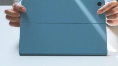 girls hand touches the screen of a tablet computer, who read, study at home and study online on a smartphone. The girl works on a tablet at home.