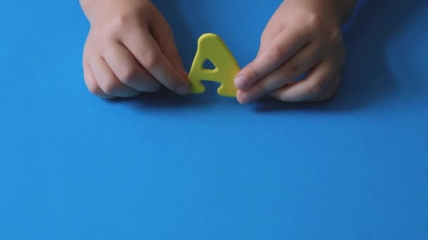 Mãos Das Crianças Acenam Letra Carta Amarela Sobre Fundo Azul — Vídeo de Stock