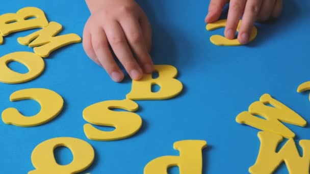 Childs Hand Playing Letters Alphabet School Start Yellow Letters Blue — Αρχείο Βίντεο