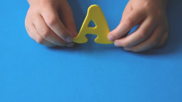 Ręce Dziecka Machają Literą Żółta Litera Niebieskim Tle Przygotowanie Szkoły — Wideo stockowe