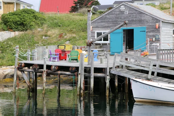 古い木造船所は 漁具や物資のための店である青の建物の隣にあります — ストック写真