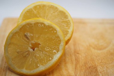 The fresh lemon slice are on the cutting board.