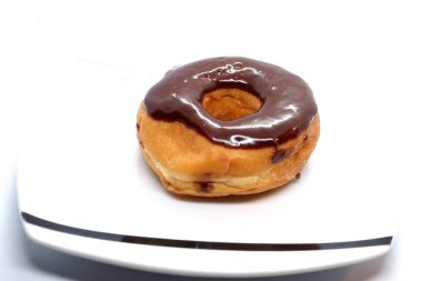 The chocolate covered  donut looks delicious.