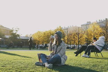 Kadın turist şehirde dolaşıp fotoğraf çekiyor.