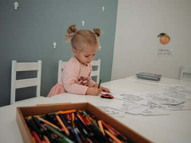 Kağıda kalem çizen küçük bir kız.