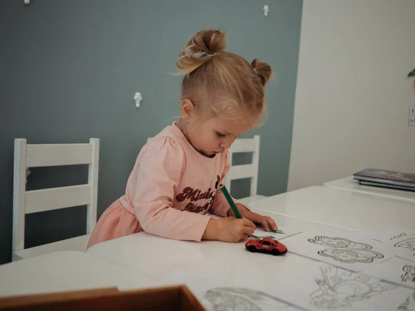 Kağıda kalem çizen küçük bir kız.