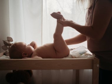 Anne ve bebek anne masaj masasını değiştiren bebek