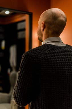 Adam aynada yansımasına bakar.